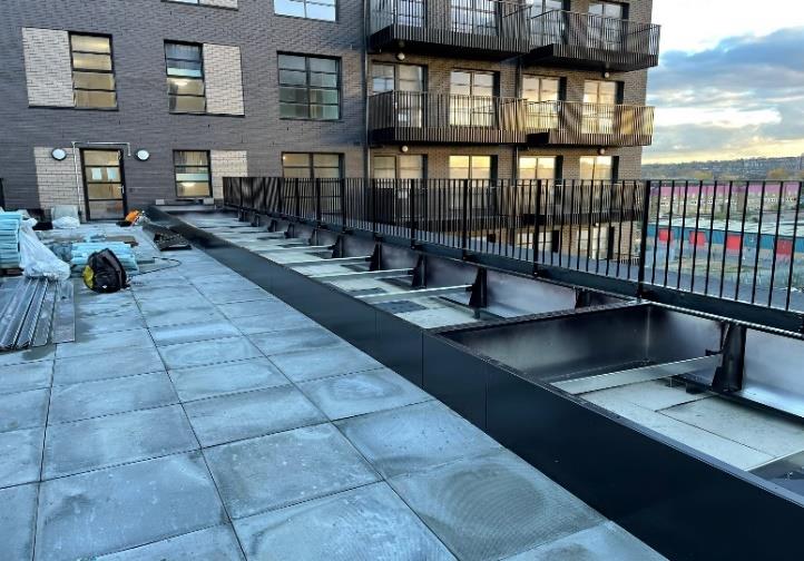 180 Ilderton Road — Q-kerb aluminium planter run installed along the perimeter rail — matte black PPC.